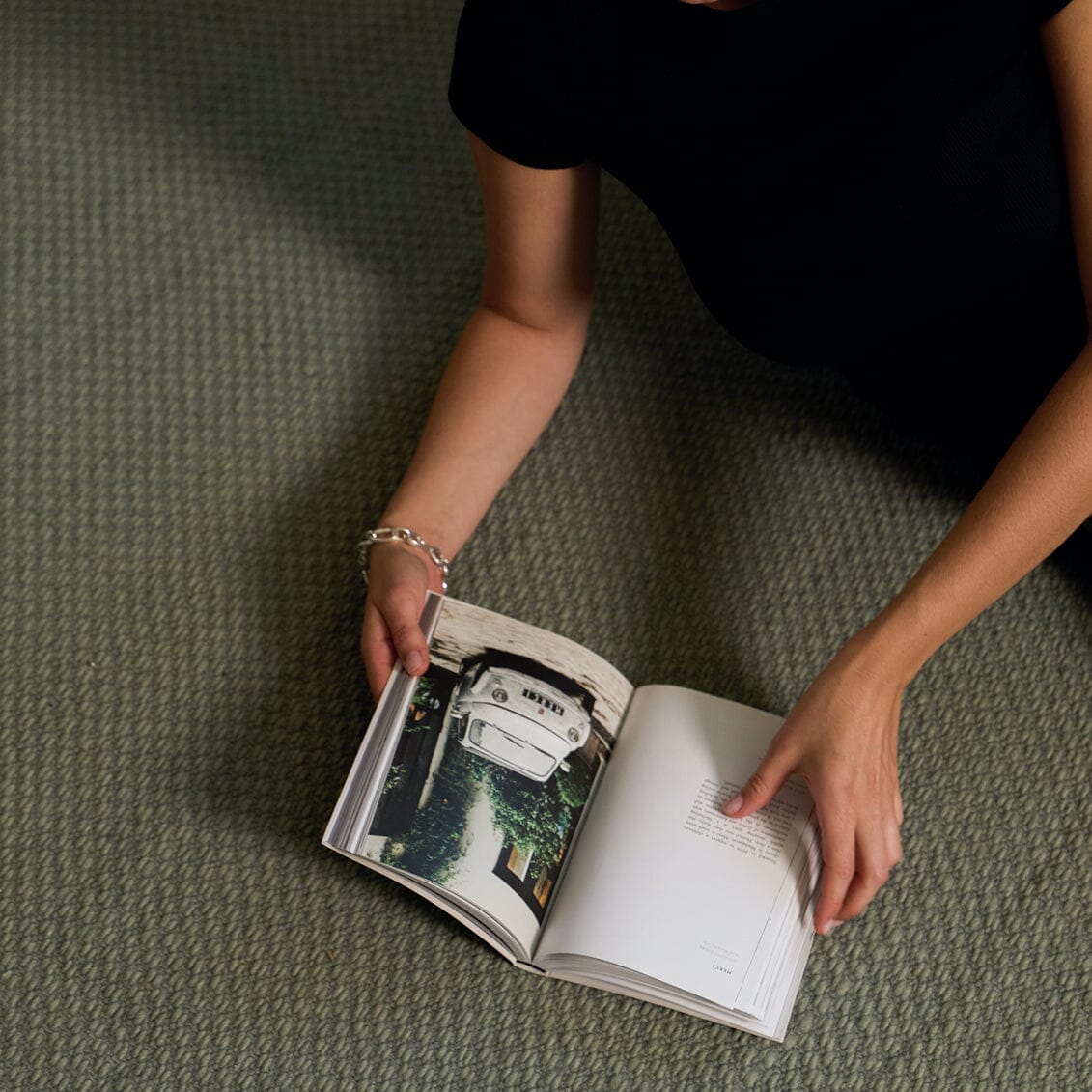 Person holding an open book on a textured green surface #sagegreen