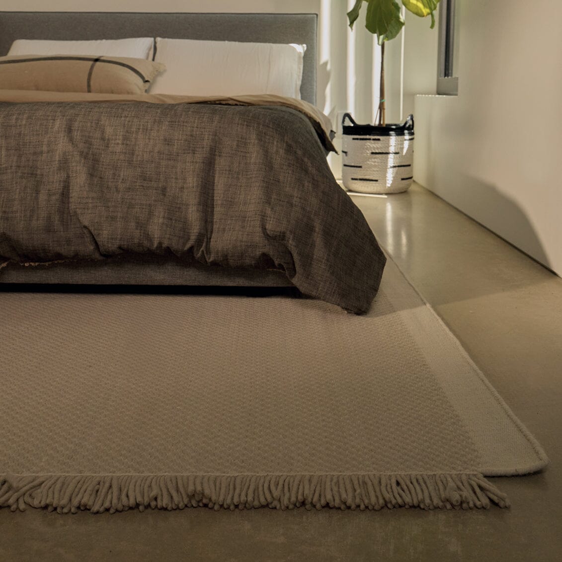 Beige rug in front of a bed with brown bedding in a bedroom setting. #foggray