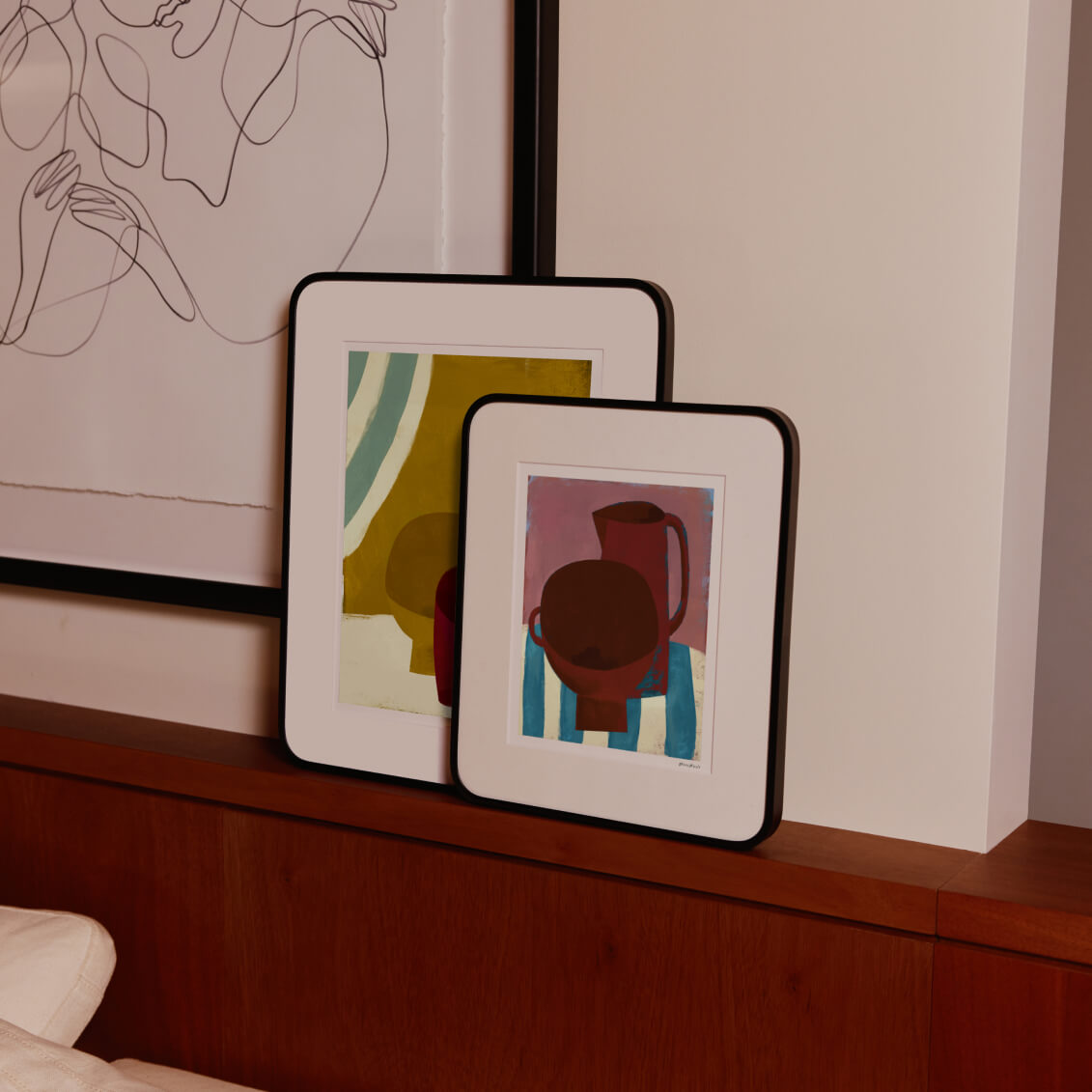 Two framed artworks on a wall with abstract designs